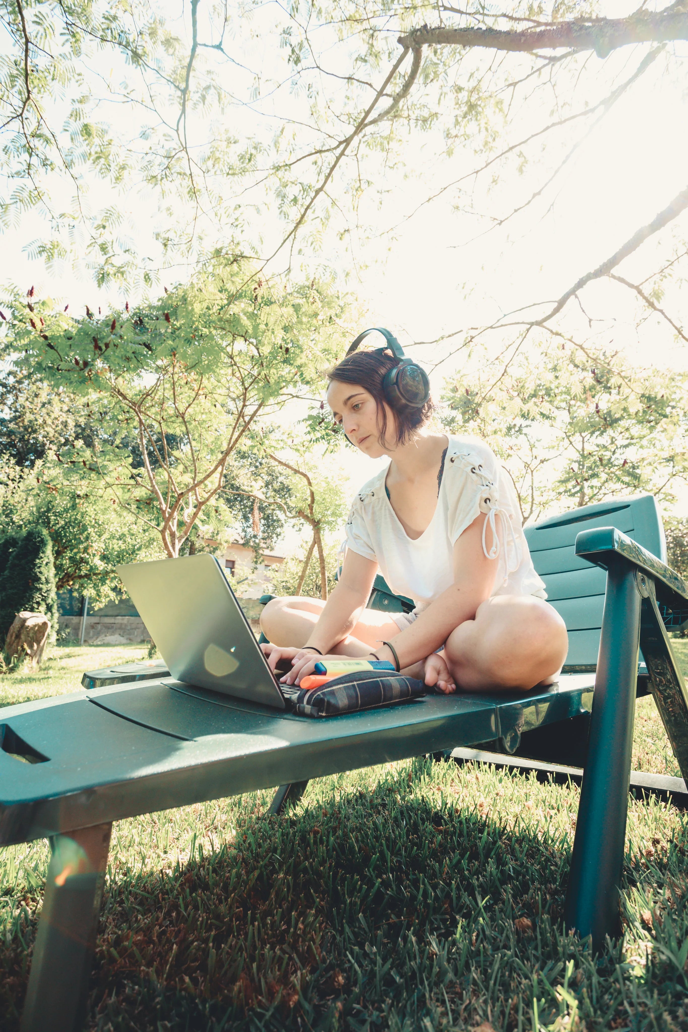 files/woman-works-on-her-laptop-outdoors-in-green-lawn-chair.webp